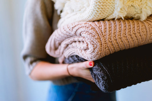 Woman holding pile of washed woolens