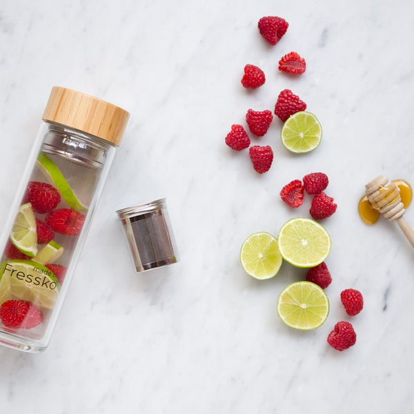 Raspberry and Lime infused water inside fressko flask surrounded by raspberries and limes